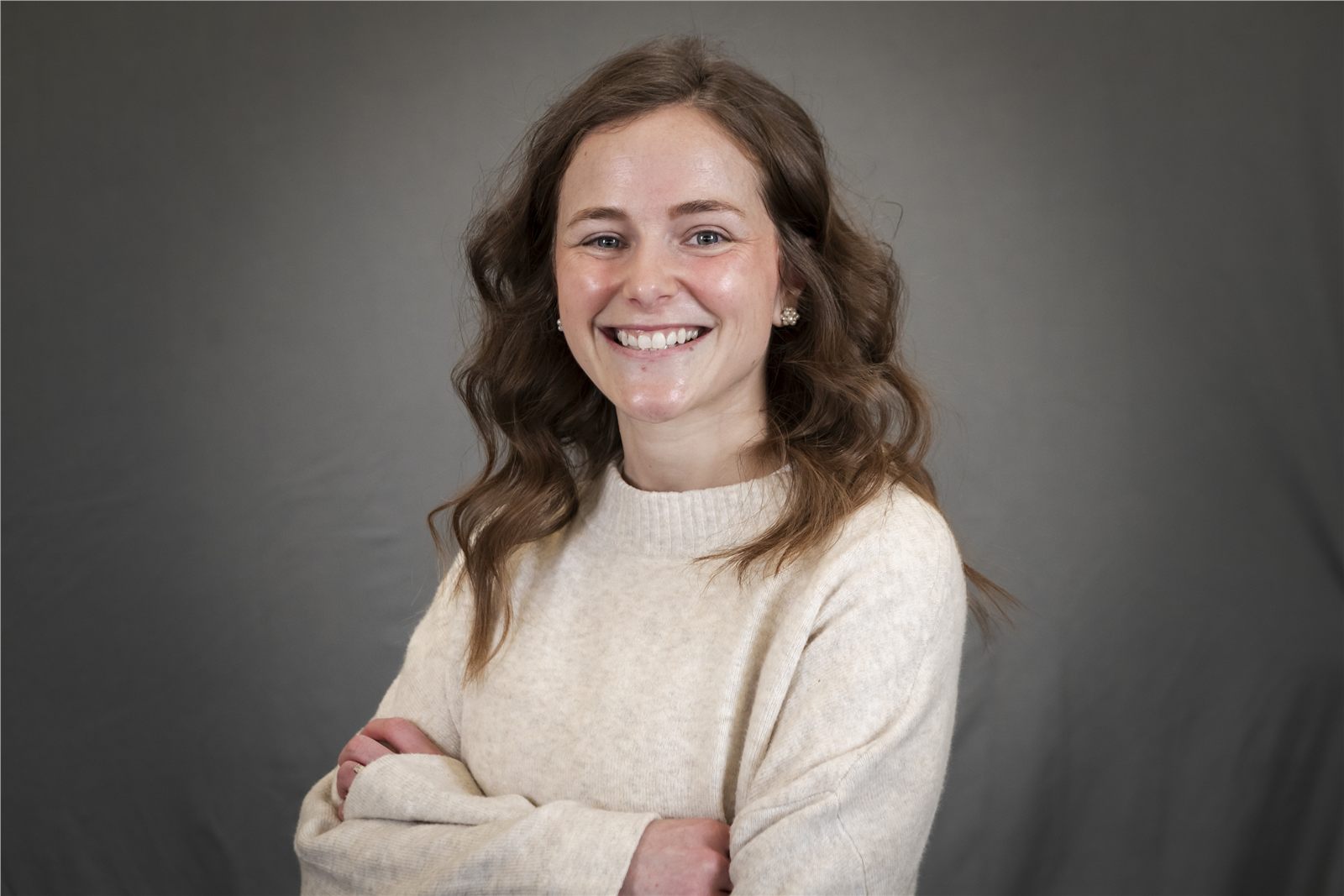 Corporate headshot of a smiling woman with arms crossed
