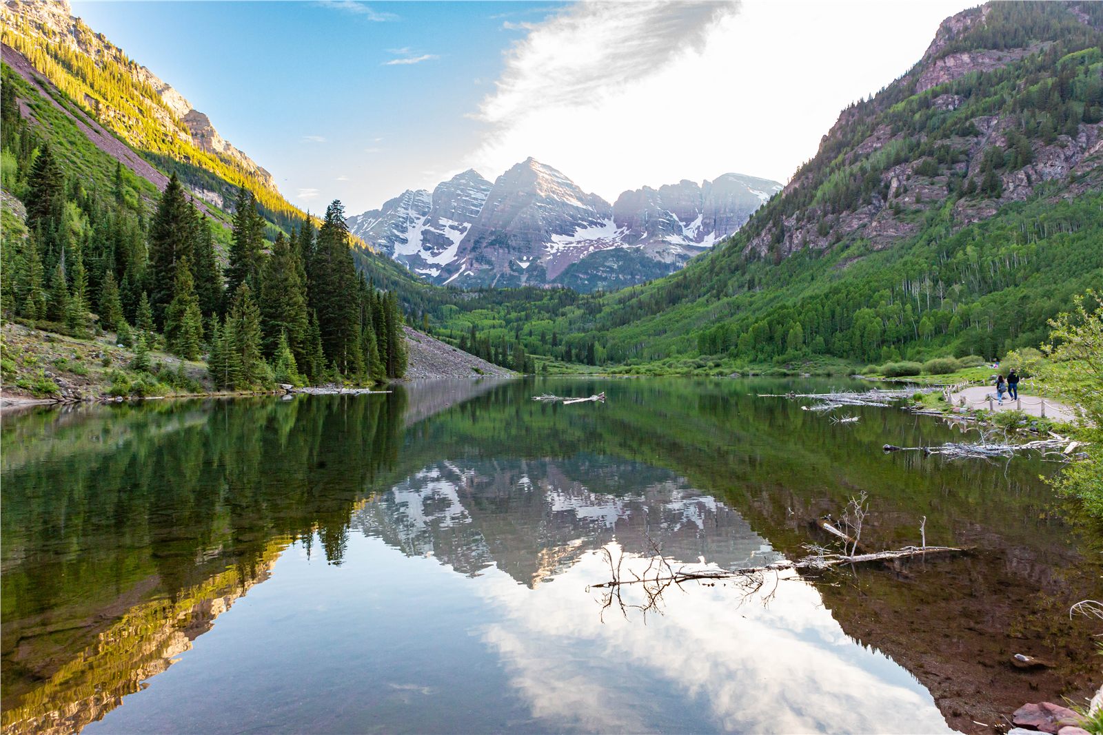 Mountain peaks and evergreen forest reflected in a clear alpine lake