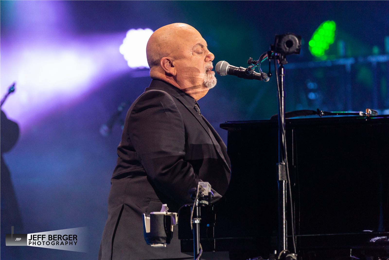 Billy Joel performing at a piano on stage