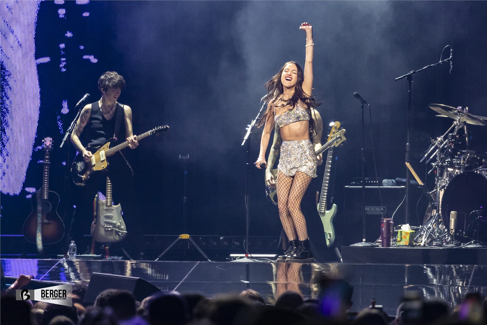 Olivia Rodrigo performing on stage with a live band