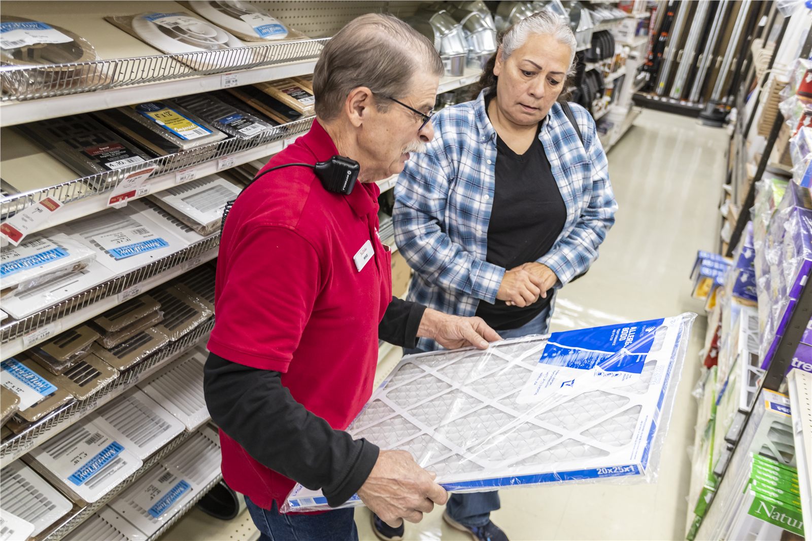 Retail associate helping a customer compare products in an aisle